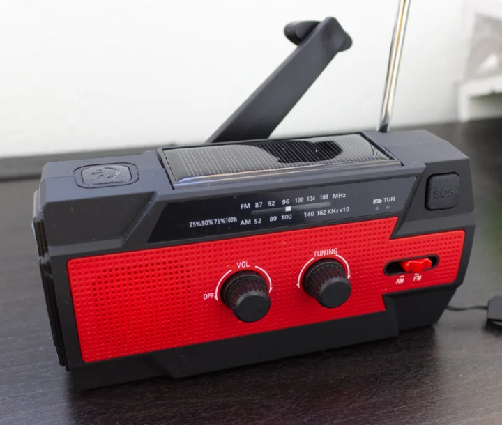 A photo of the radio we used. It's black and red, and rather rectangular. It has a small solar panel on top which can be lifted up to reveal a light. It also has a torch on the side, plus a handcrank and an SOS button. It's a very cluttered design.