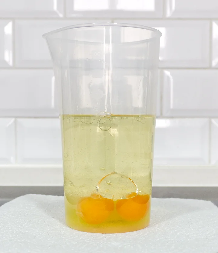 A picture of my eggs, oil, mustard, salt and lemon juice, sitting in a measuring jug. They form vague layers.