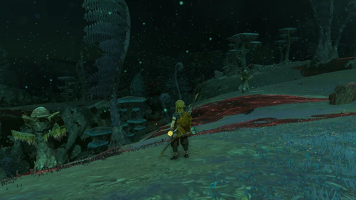 A picture focusing on how far you can see in the depths once they're lit up. Link stands in the center, but we can see mountains and trees far into the distance.