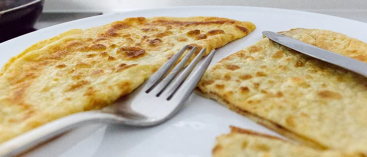 Two pancakes, folded on a plate. You can't see it but they've got sugar and cinnamon on the inside! Delicious.